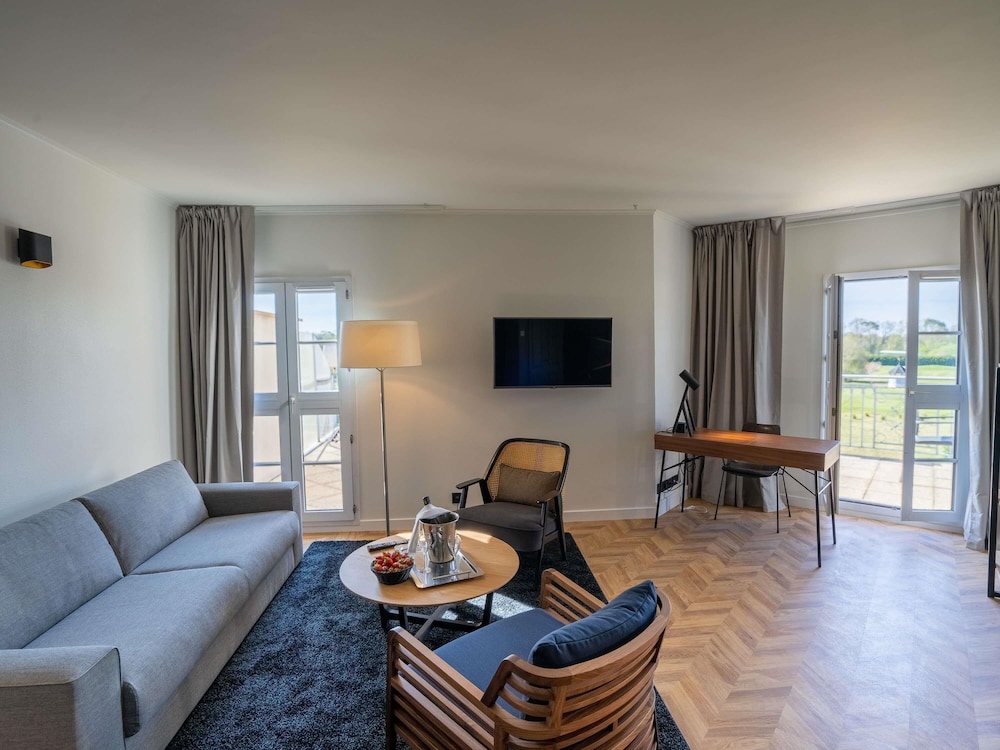 Suite Junior con 1 cama king size y sofá del hotel Mercure Chantilly Resort and Conventions