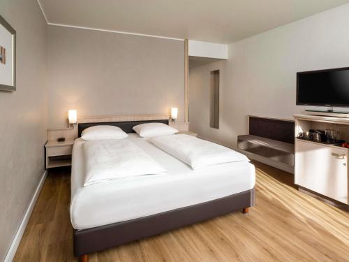 Habitación Superior con cama extragrande del hotel Mövenpick München Airport. Foto 1