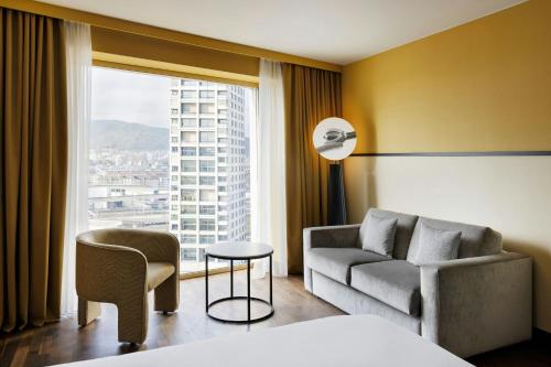 Habitación familiar con 2 camas dobles y sofá cama - Vistas a la ciudad del hotel Renaissance Zürich Tower. Foto 2