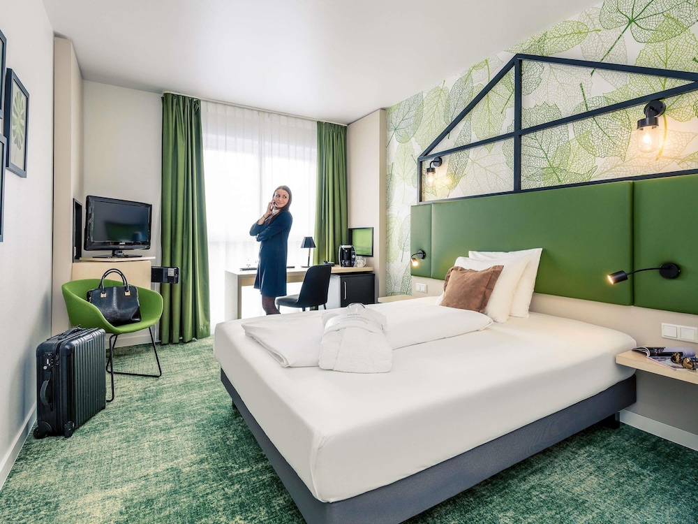Habitación Privilege con cama de matrimonio y sillón del hotel Mercure Hannover Mitte