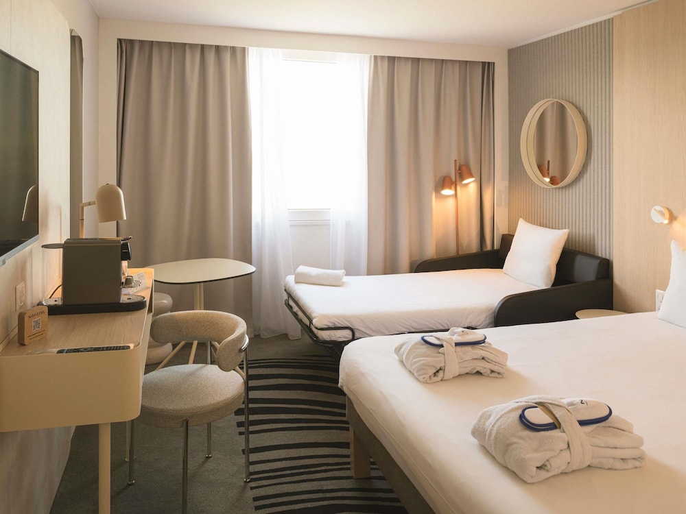 Habitación Executive con vistas al lago, cama queen size y un sofá cama individual del hotel Novotel Bordeaux Lac