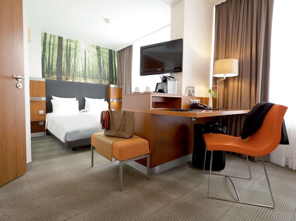 Habitación Ejecutiva con 1 cama queen size y sofá del hotel Novotel Erlangen. Foto 2