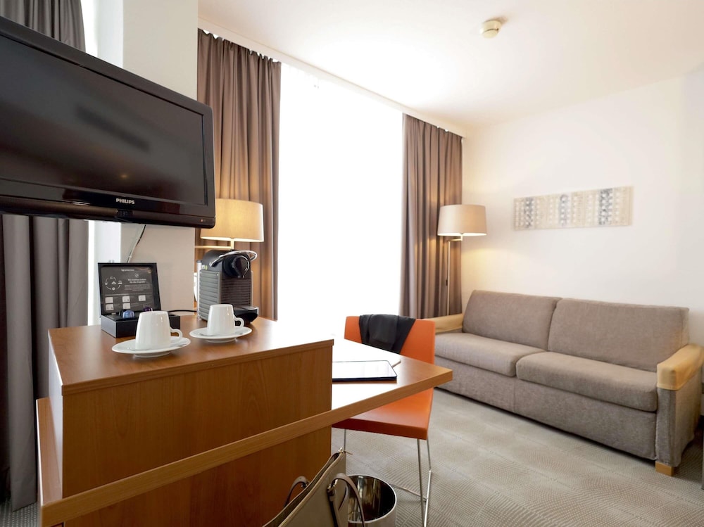 Habitación Ejecutiva con 1 cama queen size y sofá del hotel Novotel Erlangen. Foto 4