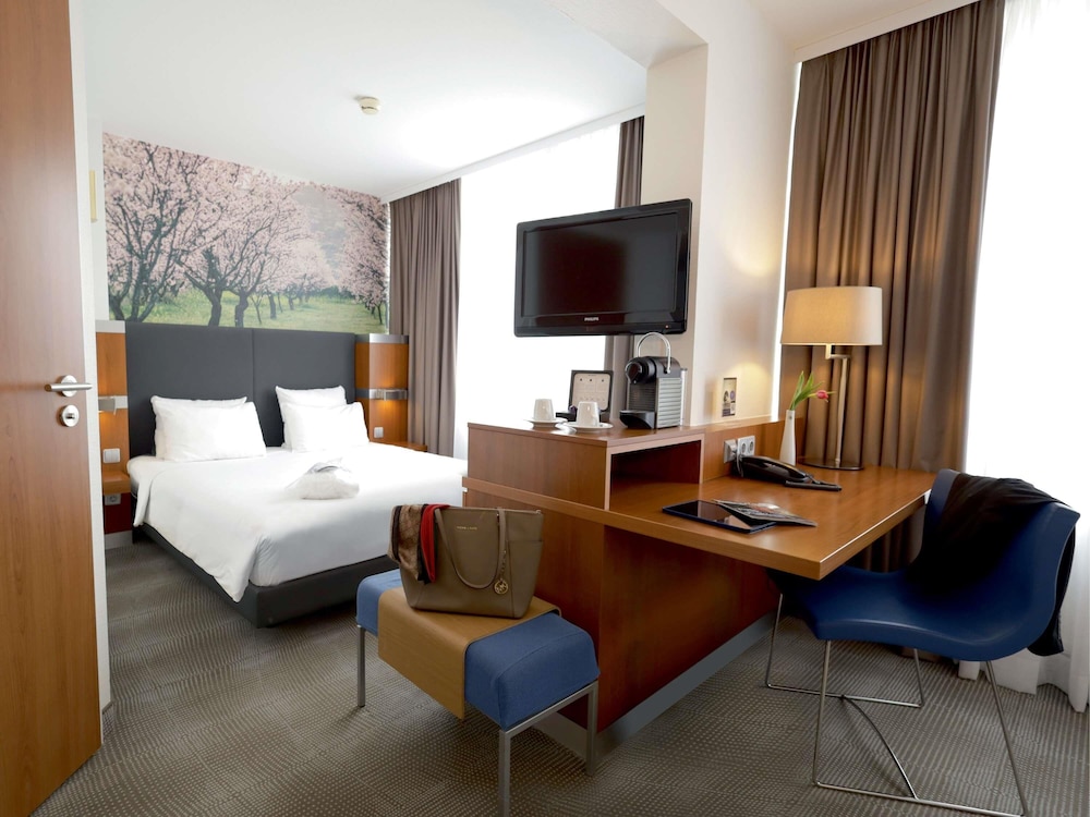 Habitación Ejecutiva con 1 cama queen size y sofá del hotel Novotel Erlangen. Foto 5