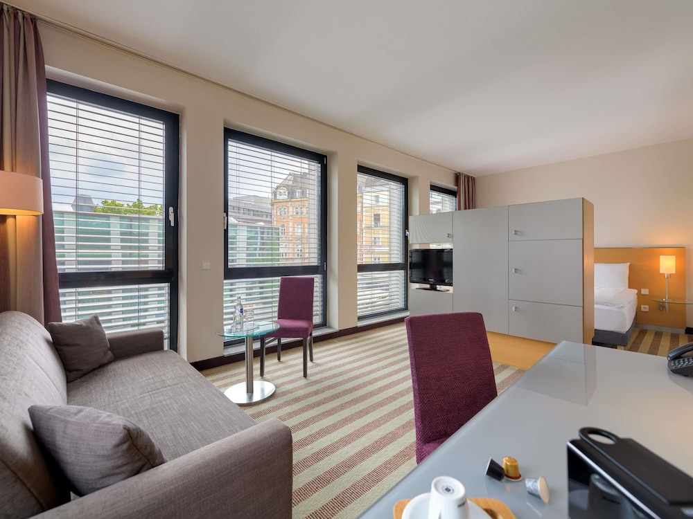 Habitación Privilege con cama doble y sofá del hotel Mercure Aachen Am Dom