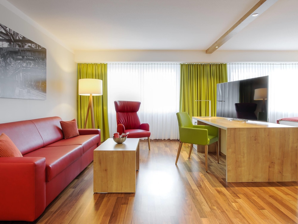 Habitación Privilege con cama doble y sofá del hotel Mercure Saarbrücken City