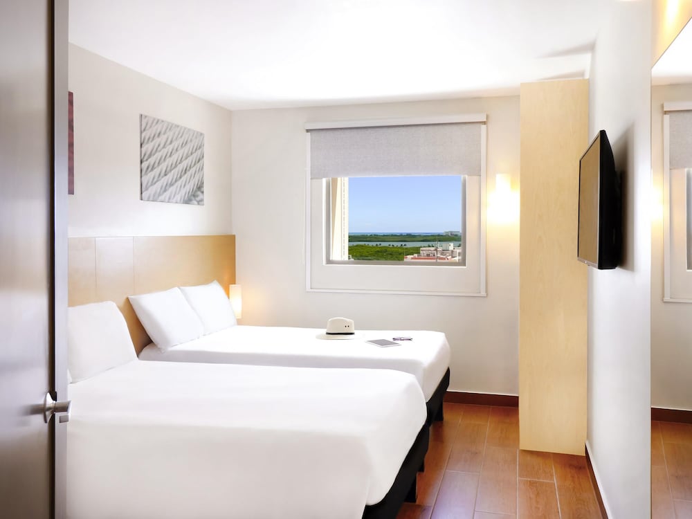 Una cama matrimonial, WiFi, televisor de pantalla plana LED y cuarto de baño con ducha del hotel Ibis Cancun Centro. Foto 6