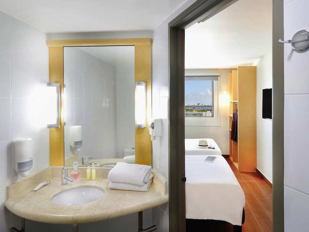 Una cama matrimonial, WiFi, televisor de pantalla plana LED y cuarto de baño con ducha del hotel Ibis Cancun Centro. Foto 17