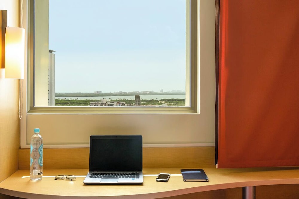Una cama matrimonial con vista a la laguna, Caja fuerte, frigo - bar, cama matrimonial del hotel Ibis Cancun Centro. Foto 5