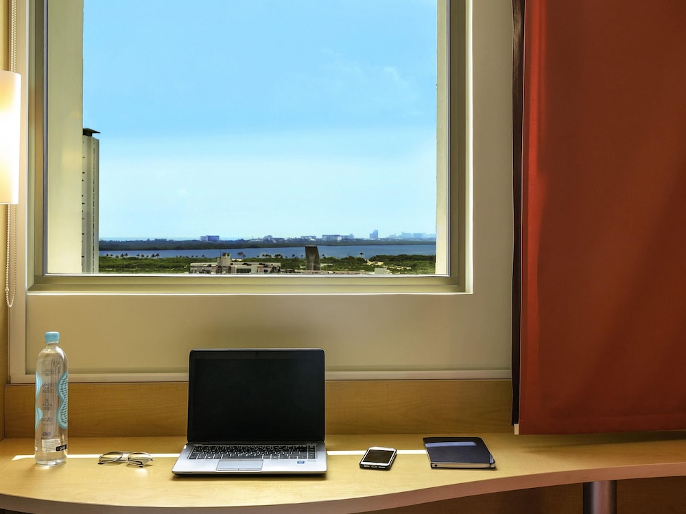Una cama matrimonial con vista a la laguna, Caja fuerte, frigo - bar, cama matrimonial del hotel Ibis Cancun Centro. Foto 7