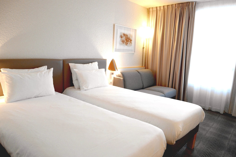 Habitación Standard con 1 cama king size o 2 camas individuales y 1 sofá cama individual del hotel Novotel Grenoble Nord Voreppe. Foto 1