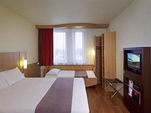 La habitación familiar estándar cuenta con 1 cama doble y 1 cama individual del hotel Ibis Krakow Stare Miasto. Foto 1