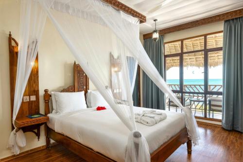 Habitación con cama grande y vistas al mar del hotel Nungwi Beach Resort by Turaco. Foto 3