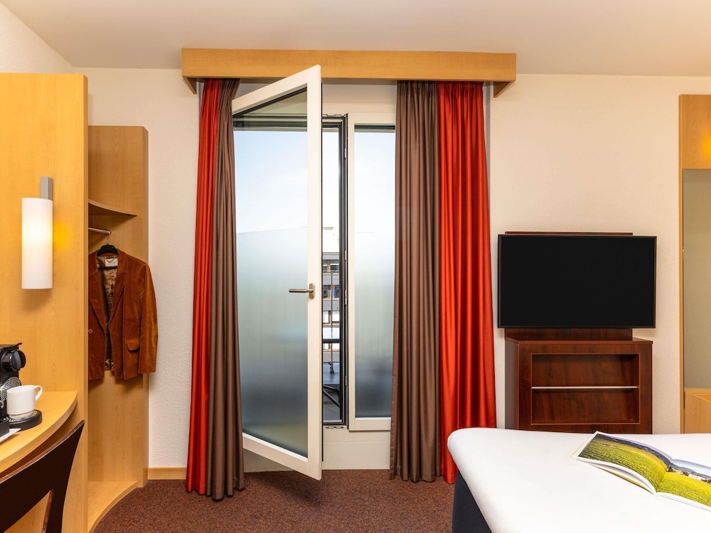 Habitación panorámica con cama doble y balcón, nuevo concepto de confort de sueño del hotel Ibis Basel Bahnhof