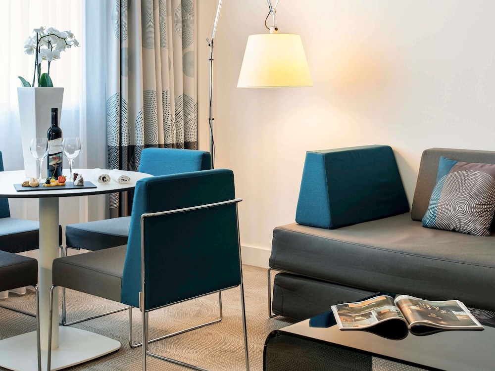 Suite con una cama king size y sofá cama del hotel Novotel Lugano Paradiso