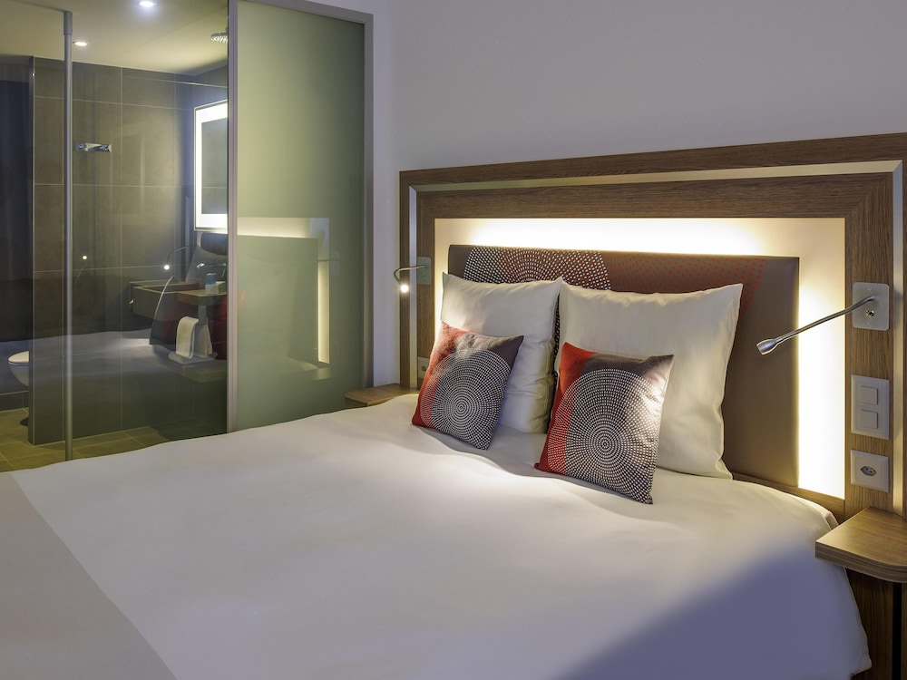 Habitación de categoría superior con una cama doble para huéspedes con limitaciones físicas del hotel Novotel Lugano Paradiso
