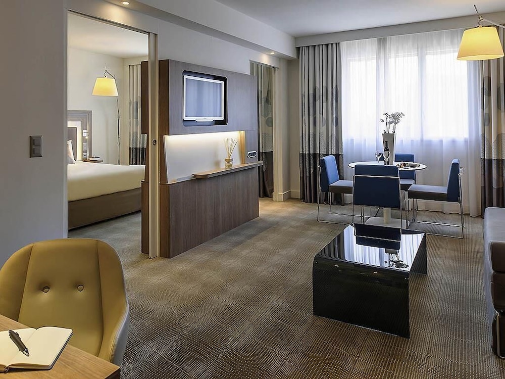 Suite con una cama king size y sofá cama del hotel Novotel Lugano Paradiso