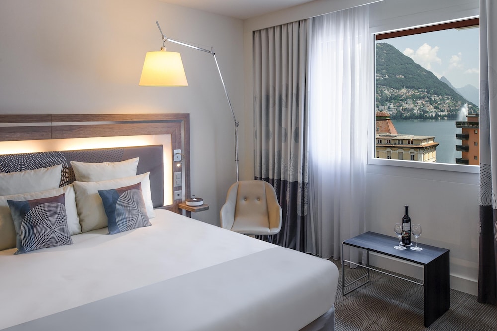 Suite con una cama king size y sofá cama del hotel Novotel Lugano Paradiso. Foto 1
