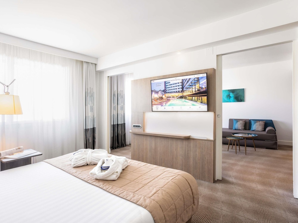 Suite con una cama king size y sofá cama del hotel Novotel Lugano Paradiso. Foto 3