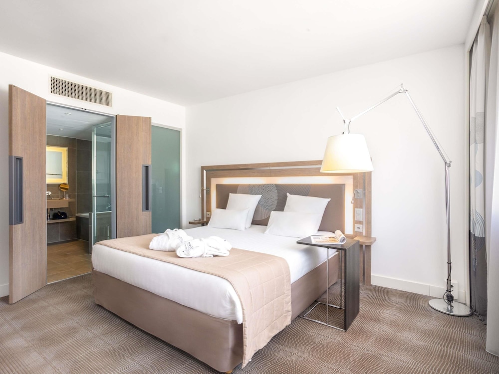 Suite con una cama king size y sofá cama del hotel Novotel Lugano Paradiso. Foto 6