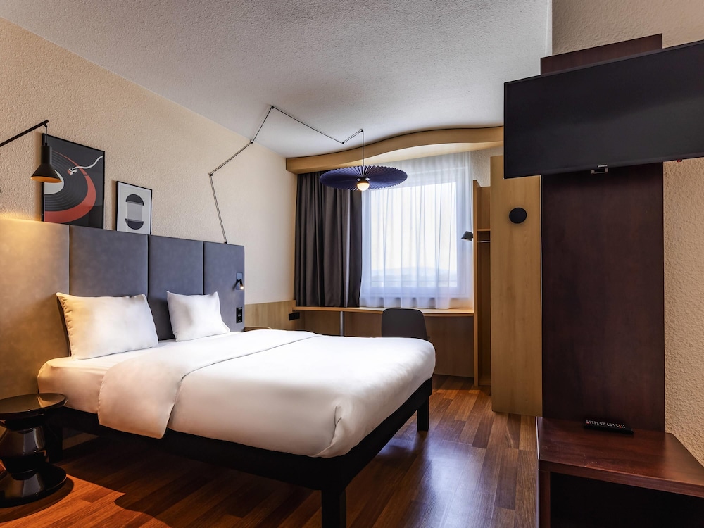 Habitación con cama doble y sofá del hotel Ibis Friedrichshafen Airport Messe