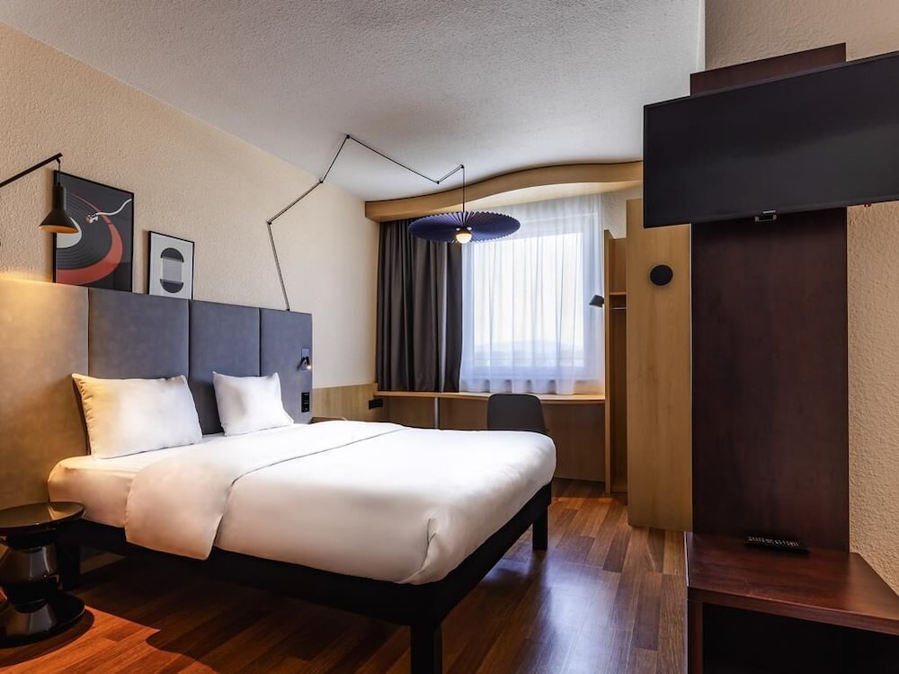 Habitación con cama doble y sofá del hotel Ibis Friedrichshafen Airport Messe. Foto 3