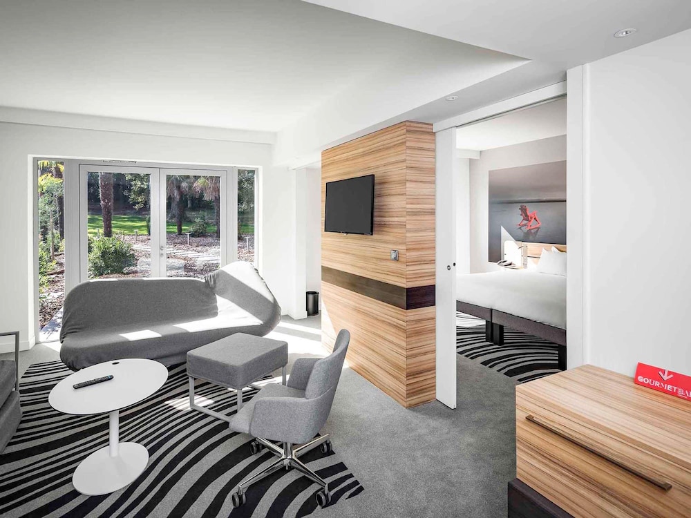 Suite de categoría superior con una cama de matrimonio y un sofá cama del hotel Novotel Resort and Spa Biarritz Anglet