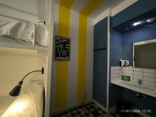Cama en habitación compartida mixta con 6 camas y baño privado del hotel Feel Hostels Soho Malaga. Foto 1