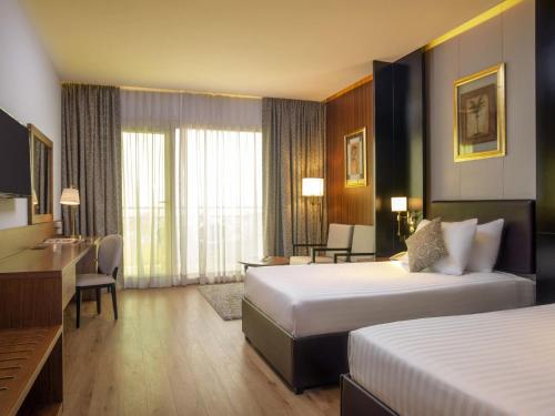 Habitación Doble Executive con vistas a la piscina y al jardín - 2 camas del hotel Movenpick Cairo Media City. Foto 1
