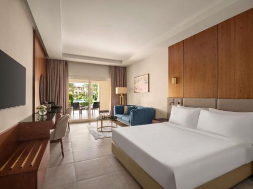 Habitación Premier con cama extragrande y vistas a la piscina del hotel Movenpick Cairo Media City
