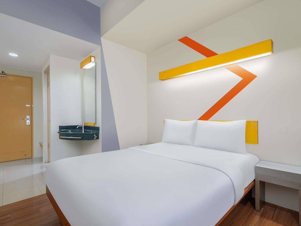 1 cama queen size del hotel Ibis Budget Jakarta Cikini. Foto 1
