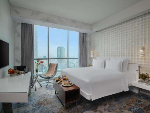 Habitación doble deluxe con cama grande y vistas al parque del hotel Pullman Jakarta Central Park