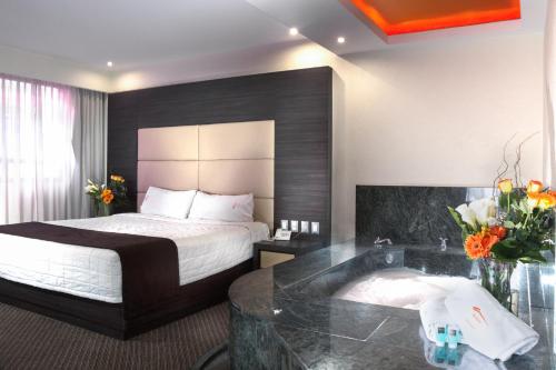 Habitación con cama extragrande y bañera de hidromasaje del hotel Astor. Foto 1