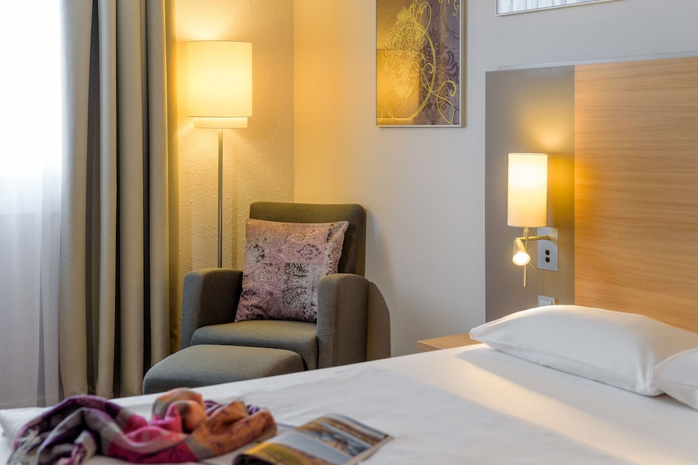 Habitación Standard con una cama doble y un sillón del hotel Fuerther Mercure Nuernberg West. Foto 1