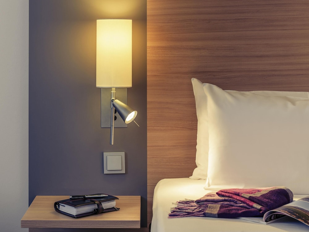 Habitación Standard con una cama doble y un sillón del hotel Fuerther Mercure Nuernberg West. Foto 4