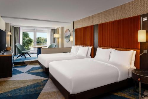 Habitación Deluxe con 2 camas grandes y vistas al paseo marítimo del hotel Hilton Vienna Danube Waterfront