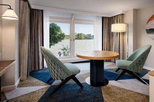 Habitación Deluxe con 2 camas grandes y vistas al paseo marítimo del hotel Hilton Vienna Danube Waterfront. Foto 1