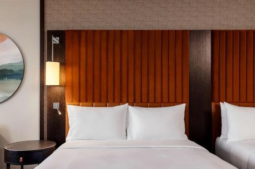Habitación Deluxe con 2 camas grandes y vistas al paseo marítimo del hotel Hilton Vienna Danube Waterfront. Foto 2