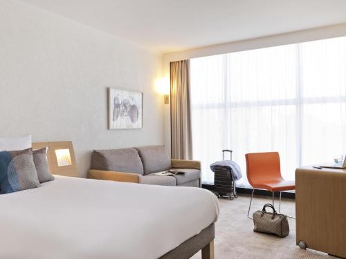 Habitación Superior con cama grande y sofá del hotel Novotel Geneve Centre