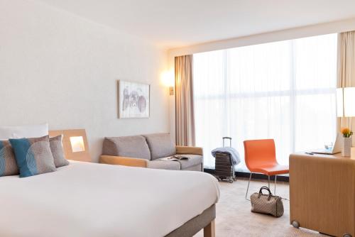 Habitación Superior con cama grande y sofá del hotel Novotel Geneve Centre. Foto 4